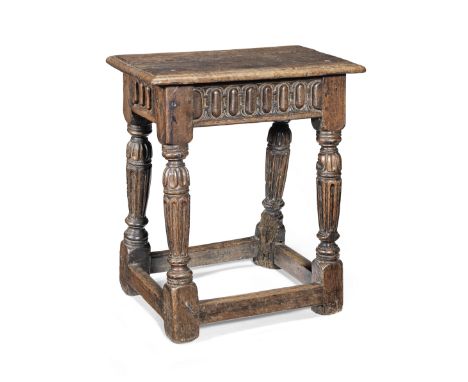 A rare Elizabeth I oak and walnut joint stool, circa 1580The top with ovolo-moulded edge, the rails carved with raised-nullin