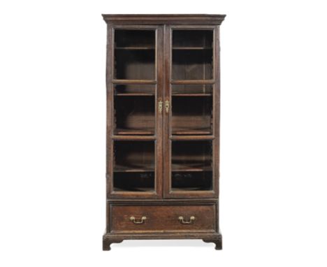 A George I joined oak and glazed bookcase, circa 1720Of narrow upright proportions, having a cyma-recta cornice, and a pair o