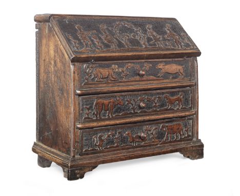 A mid-18th century fruitwood miniature bureau, possibly Dutch, circa 1750The hinged sloping fall carved with an unusual table