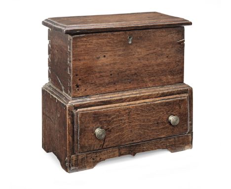 A George III miniature boarded oak chest with drawer, Welsh, circa 1800Having an edge-moulded and hinged lid, the front board