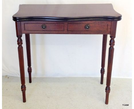 A mahogany card table standing on column supports