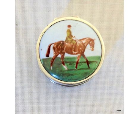 A silver enamel pill box depicting horse and rider