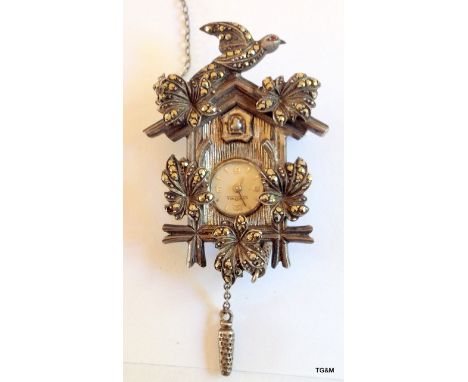 A silver cuckoo clock brooch