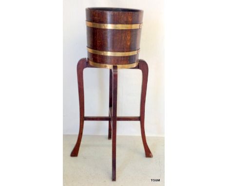 A brass bound oak planter on a 4 legged cabriole stand
