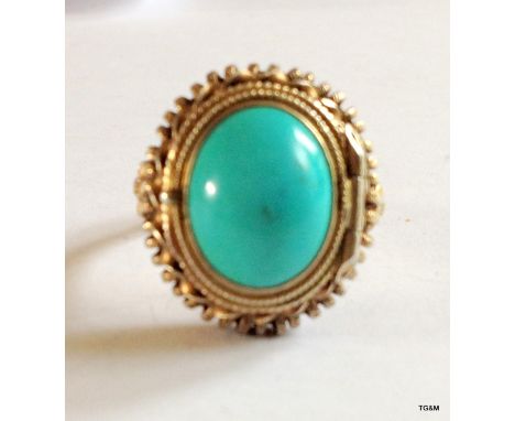 A turquoise and silver ring with opening to show a turquoise Buddha inside