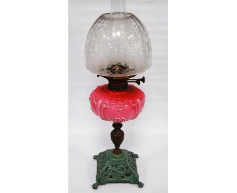 Victorian oil lamp by Wright & Butler, Birmingham, with pink opaline reservoir above a gilt metal urn column and painted iron
