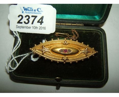 A Victorian 15ct Gold Cushion style Brooch set with a Ruby and two Diamonds.