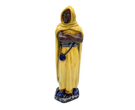 Rare color variation, hand decorated fine china figure of the Moor. Depicts a man in a vibrant yellow hooded cloak, and blue 