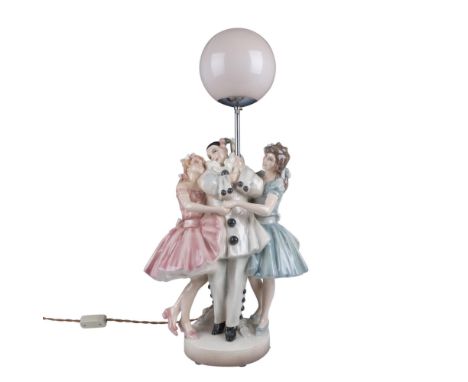 Beautiful glazed porcelain piece with and Art Deco style, modeled as a lovely scene of a Pierrot clown flanked by two women. 