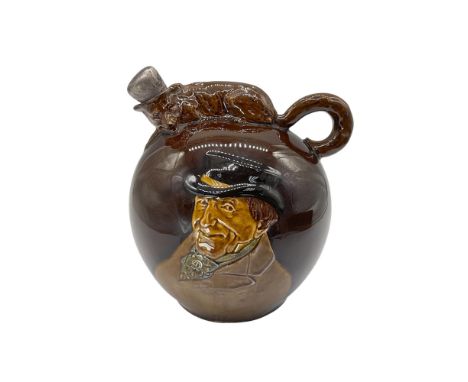 Rich dark brown glaze. Flask with crouching fox on the top, the brushy tail forming the handle. On the face is relief image o