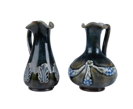 A pair of midnight blue miniature pitchers that are decorated with white and blue flowers and foliage. Royal Doulton backstam