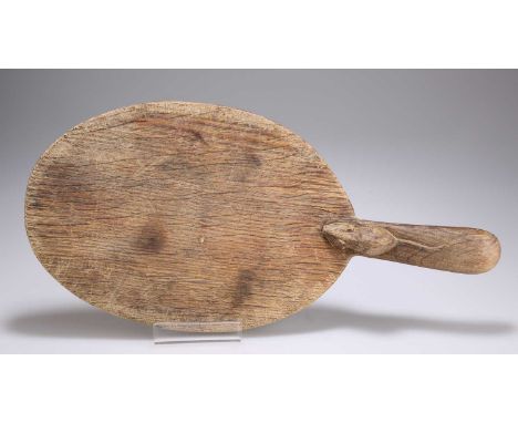 ROBERT THOMPSON OF KILBURN, A MOUSEMAN OAK CHEESEBOARD typical oval form, with carved mouse signature. 37.5cm across handle