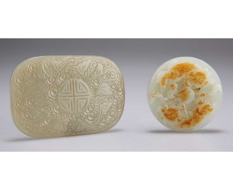 TWO CARVED JADE PLAQUES  one of circular form, carved to one side with mythical creatures chasing a brocade ball, the other s