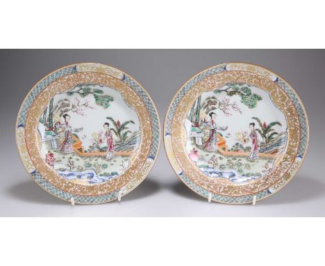 A PAIR OF FAMILLE ROSE PLATES 19th Century, circular, enamelled with figures in a garden setting, embellished with gilding. (