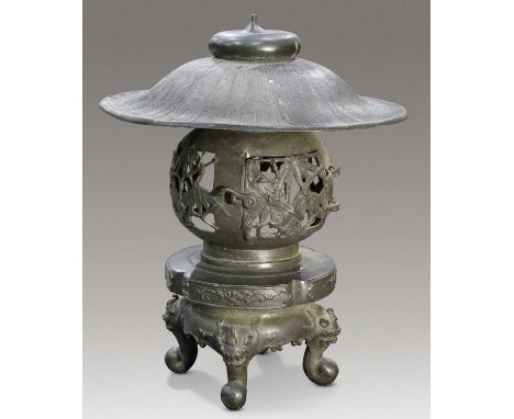 A JAPANESE BONZE LANTERN, MEIJI PERIOD with hinged door and oversized cover, raised on a stand cast with four masks. 49cm hig