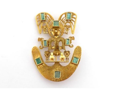 An emerald brooch, designed as an Aztec figure, mounted overall with collet set emeralds, stamped '18k' verso, 6cm long, 16.7
