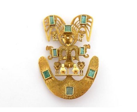 An emerald brooch, designed as an Aztec figure, mounted overall with collet set emeralds, stamped '18k' verso, 6cm long, 16.7