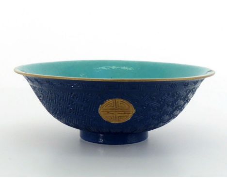 A Chinese carved porcelain bowl, decorated with gilt carved “Shou” circular characters on blue stylized pattern ground, turqu