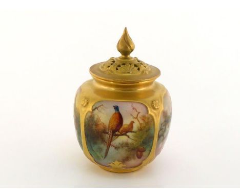 A Royal Worcester pot pourri vase with pierced cover, the gilt body with panels of pheasants in a misty landscape with fir tr