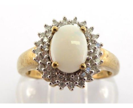 An opal and diamond cluster ring, the central oval opal cabochon 8 x 6mm, in a two tiered surround of small single cuts, the 