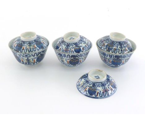 A set of three Chinese porcelain tea bowls with lids and together with a spare lid, under glazed decorated with “eight treasu