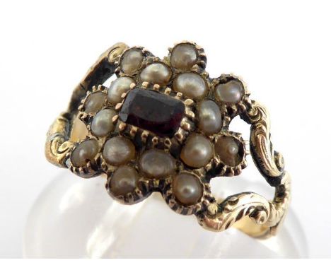 A 19th century seed pearl and garnet ring, the cluster of seed pearls to a small collet set garnet, to openwork scroll work s