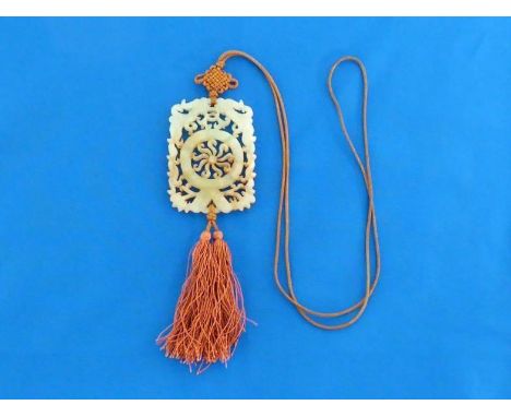 A Chinese carved nephrite jade plaque with tassel and attachment, in rectangular form, finely carve and pierced on both sides