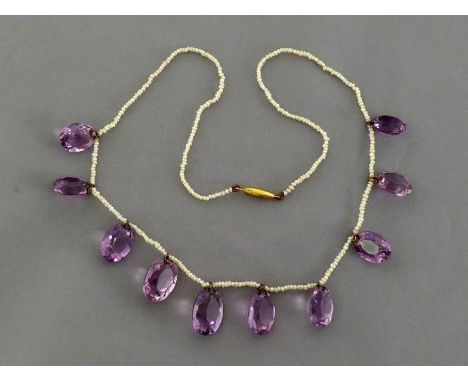 A Victorian amethyst and seed pearl necklace, the fine strand of seed pearls set along the centre with graduated oval cut ame