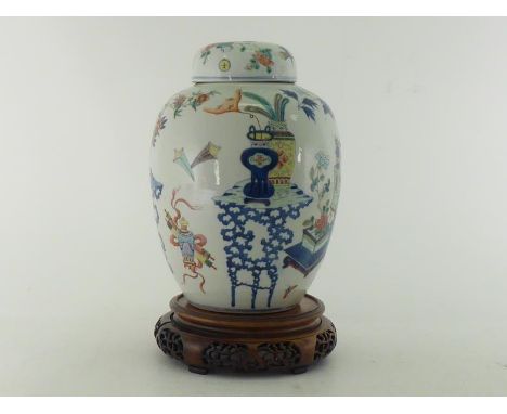 A Chinese porcelain famille rose jar and cover with carved wood stand, beautifully decorated antique treasures and flowers in