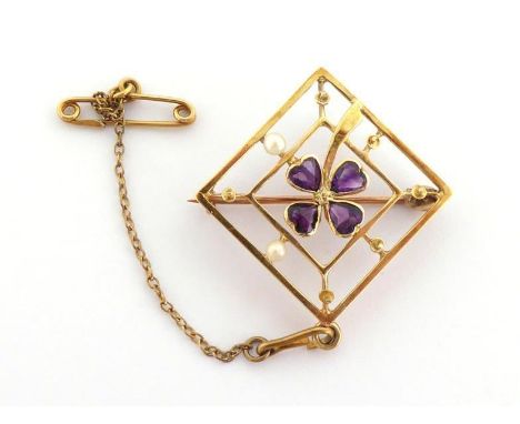 An Edwardian amethyst and seed pearl pendant, a clover of amethysts to the centre of an open work square mount, stamped '15ct
