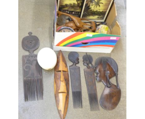 A collection of African tourist trade carvings including combs, two prints, ostrich egg, etc.