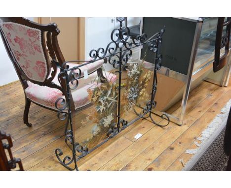 An early 20th century Scottish wrought iron and painted glass firescreen, J. Bennet, Arncroach, Fife, the scrolling frame enc