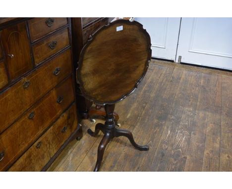 A late George III mahogany piecrust tilt-top tripod table, the (possibly associated) top above a ring-turned baluster standar