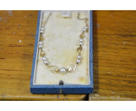 An early 20th century 9ct gold and cultured pearl necklace, the twinned graduated pearls between heart-shaped spacers, on a t