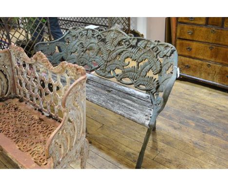 A cast iron garden bench in the Coalbrookdale style, weathered, the back and sides cast with ferns enclosing a slatted wooden