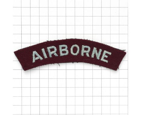 AIRBORNE WW2 cloth embroidered shoulder title. Slightly curved light blue sans-serif letters embroidered on maroon felt.   VG
