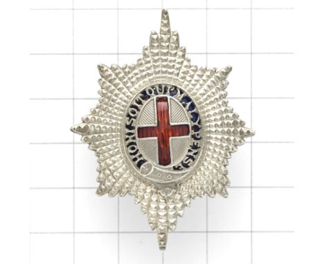 Coldstream Guards Officer’s forage cap badge. Die-cast facetted Garter Star mounted with pierced Garter on a blue enamel grou
