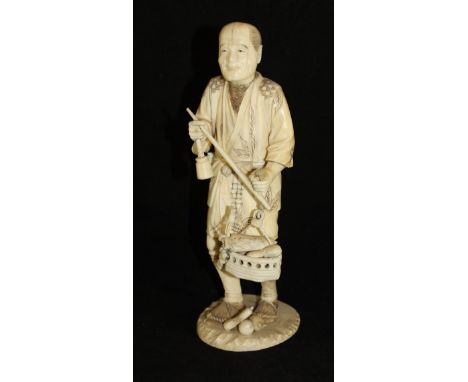 A Japanese Meiji Period carved ivory okimono as a market trader with scales and basket of gourds, signed to base, 26.8 cm hig