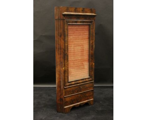 A 19th Century Continental mahogany free standing corner cabinet in the Biedermeier taste, the single glazed door with cloth 