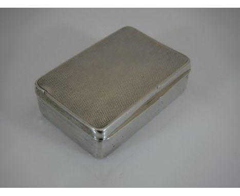 A George V silver snuff box of rectangular form, the lid with engine turned decoration opening to reveal a gilt washed interi