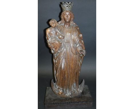 A late 17th Century carved oak figure of The Madonna and child, The Madonna wearing a tin crown and dressed in robes, her rig