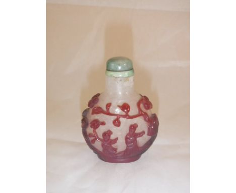 A 19th Century Chinese ruby overlaid glass scent bottle decorated with figures amongst prunus blossom with hard stone stopper