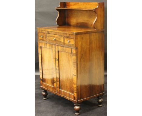 A late Regency rosewood chiffonier, the raised back with single shelf over three drawers with pressed brass handles and two c