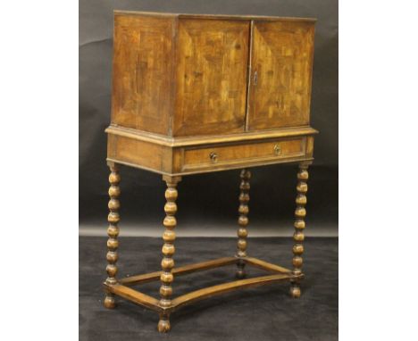 A 19th Century Continental olive wood cabinet on stand, the parquetry inlaid top over two cabinet doors similarly decorated e