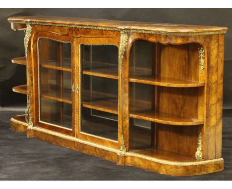 A circa 1900 French walnut and kingwood veneered credenza, the shaped top with moulded edge above two glazed panel doors encl