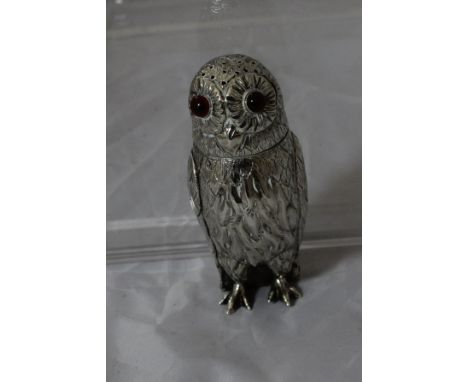 A Victorian silver pepperette in the form of an owl with red glass eyes (by George Unite, London) bears hallmark X, 9 cm high