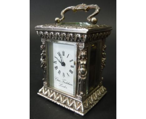 A modern silver cased carriage clock, the scrollwork swing handle with crown motif, the four glass case with carytid figures 