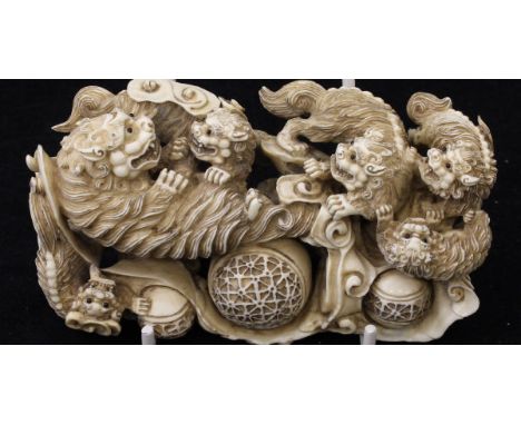 A Japanese Meiji Period carved ivory figure group as a lioness and cubs with balls amongst clouds, signed within a roundel ve