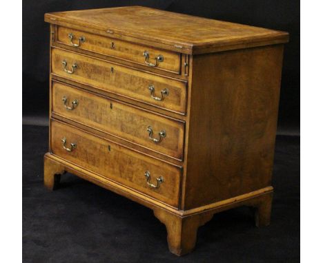 A walnut and feather banded bachelor's chest  in the 18th Century manner with fold-over top above four graduated drawers to b