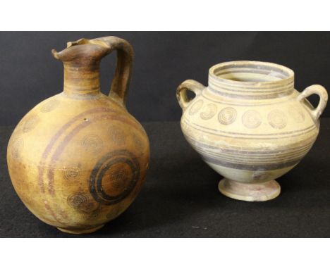 A Cypriot iron age pottery ewer or Oinochoe of globular form with roundel decoration, 25 cm high and a similar near matching 